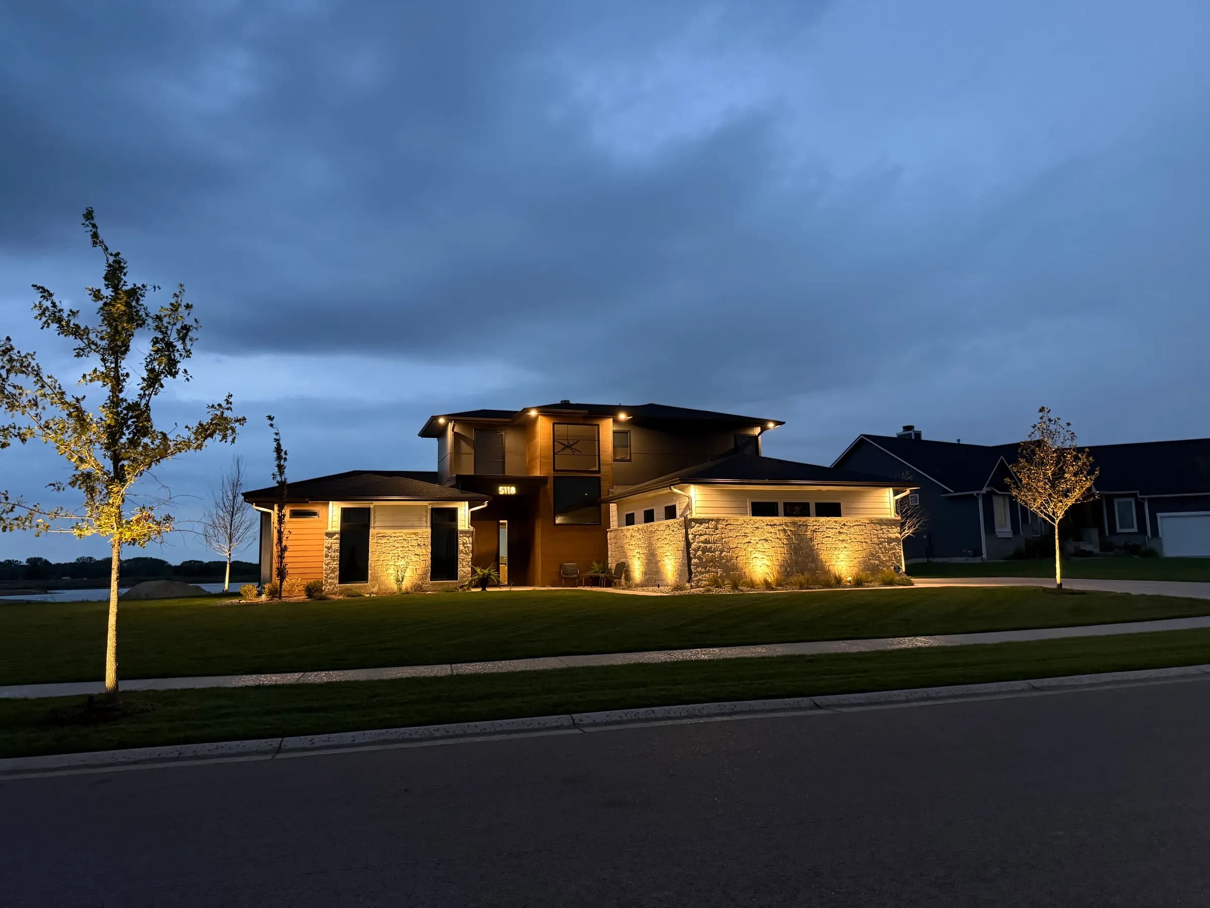 The Coves modern home front elevation lit at dusk