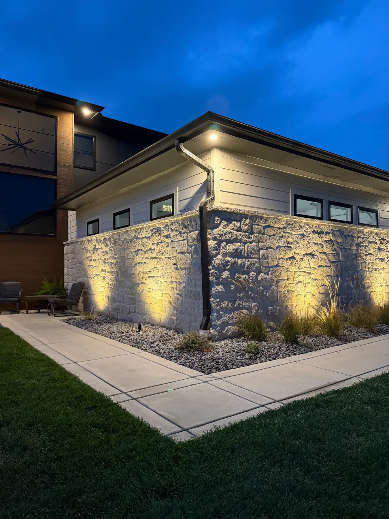 Stone corner of a Coves home washed with warm uplighting